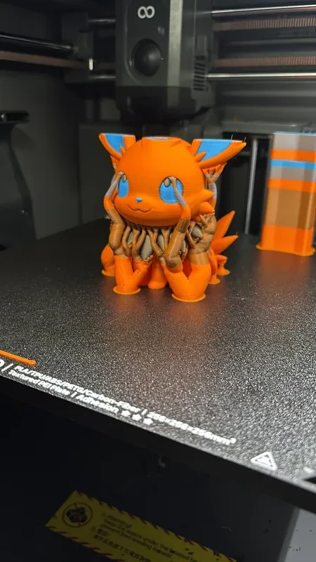 Figura multicolor impresa en 3D recién salida de la impresora